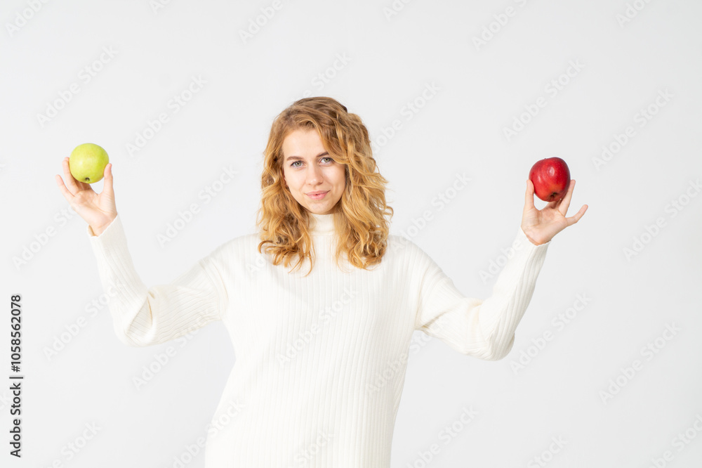 Happy attractive blonde young girl holding red and green apples, white background, copyspace. Concept of choice Happy attractive blonde young girl holding red and green apples, white background, copyspace. Concept of choice