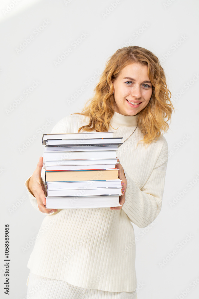 Cute young blonde girl with books in her hands, white background, copyspace Cute young blonde girl with books in her hands, white background, copyspace