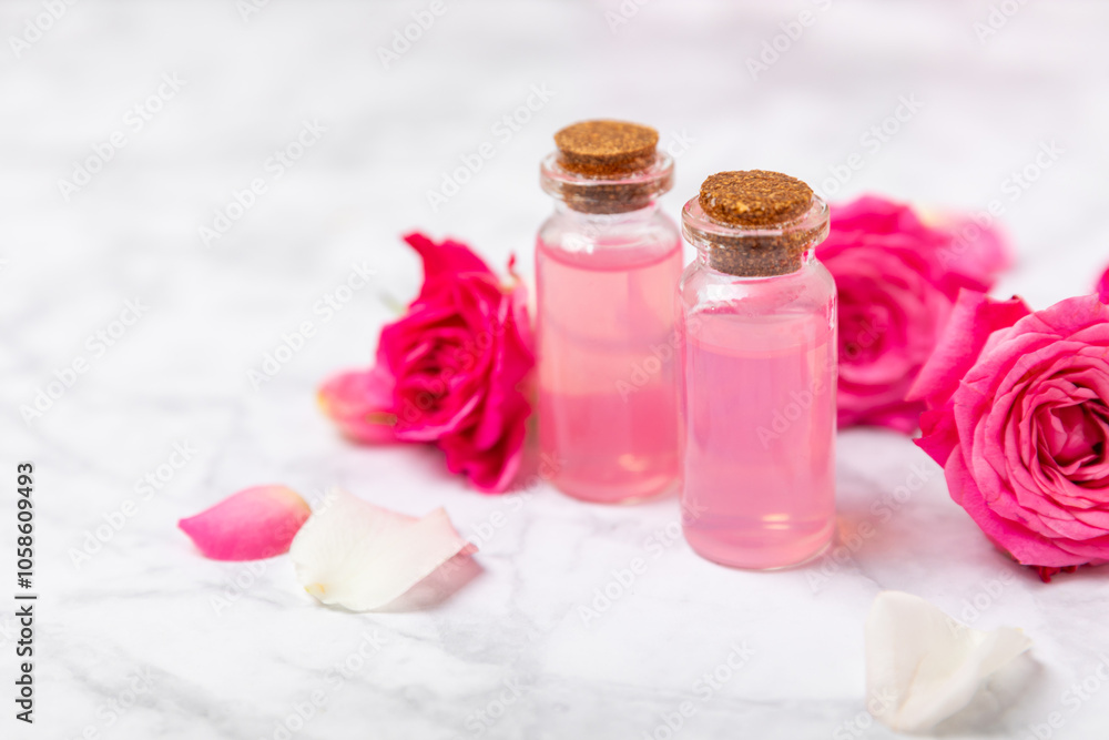 Rose essential oil on a textured background.Roses and a bottle of rose perfumed water.Aromatherapy treatment. Beauty concept. Spa procedure.Natural organic oil.Anti-stress,detox relax.Place for text Rose essential oil on a textured background.Roses and a bottle of rose perfumed water.Aromatherapy treatment. Beauty concept. Spa procedure.Natural organic oil.Anti-stress,detox relax.Place for text