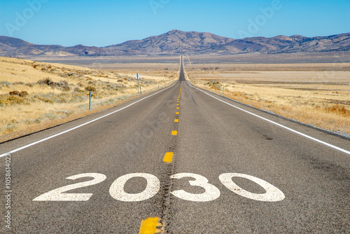 Long straight road through the desert with 2030 on the asphalt photo