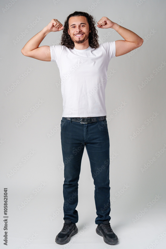 Happy man celebrating success with raised fists in a studio against a plain background Happy man celebrating success with raised fists in a studio against a plain background