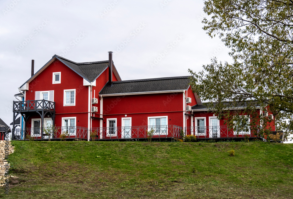 Obraz premium village with red houses and a red lighthouse on the shore of a lake on an autumn day in the Ryazan region
