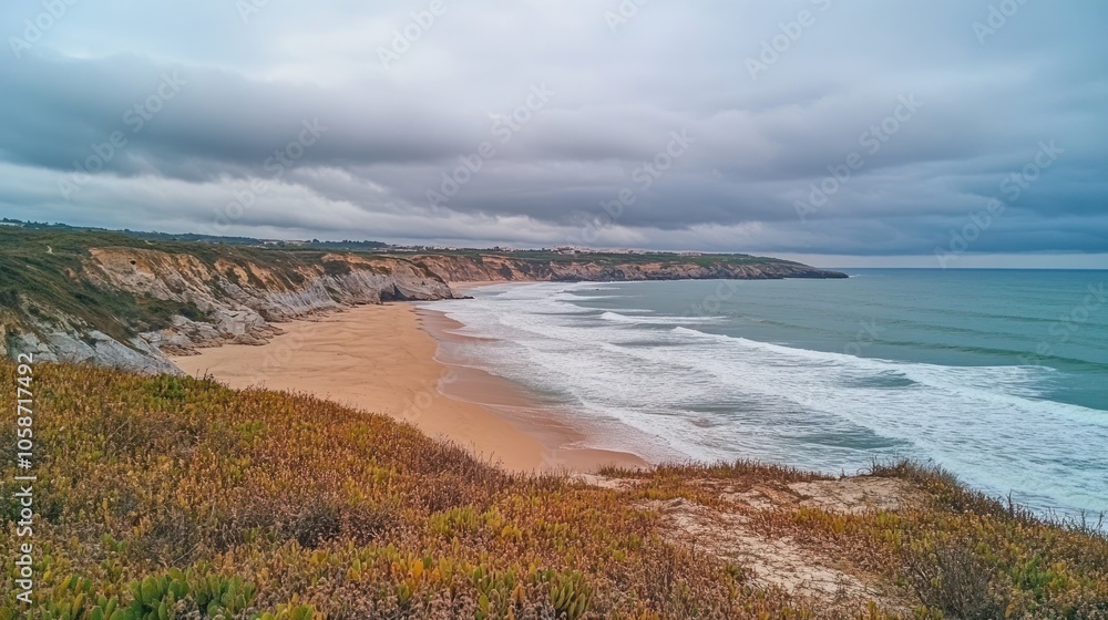 A scenic view of a sandy beach with crashing waves and a rocky coastline under a cloudy sky. A scenic view of a sandy beach with crashing waves and a rocky coastline under a cloudy sky.