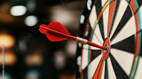 Close-up of a red dart hitting the bullseye on a colorful dartboard, symbolizing precision and accuracy in a game or competition setting.