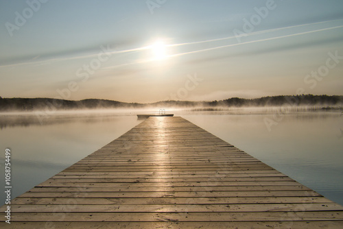 Wooden jetty in the morning at sunrise in the fog, on a Swedish lake. Scandinavian photo