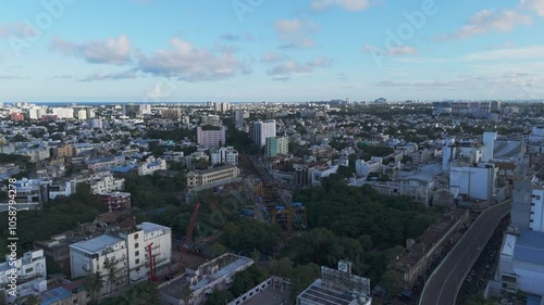 A breathtaking aerial video captures Chennai city bathed in the golden hues of sunset. From a bird's-eye view, the city's sprawling urban landscape unfolds, with its intricate network of roads photo