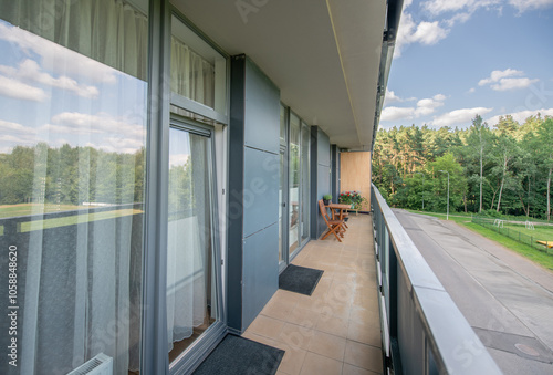 Chill Area and a Home Balcony Interior. Tiled Walls and Floor. Whitee Ceiling. Bright Suy Day, Cloudy Sky photo