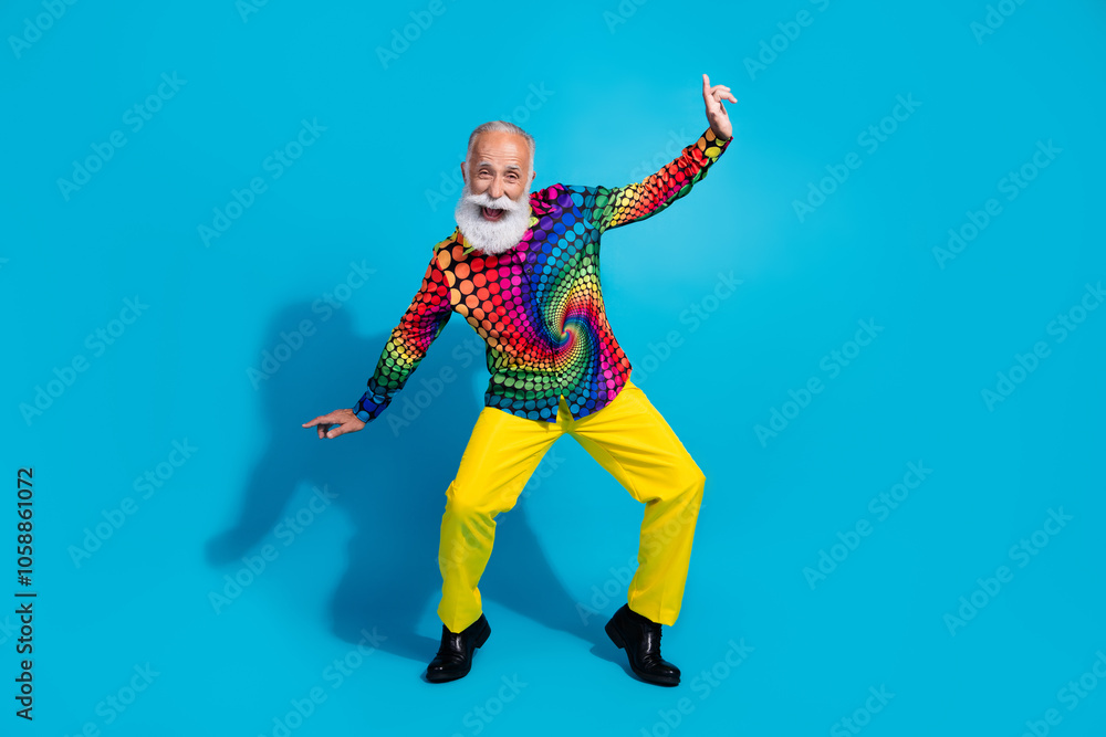 Full length photo of cool macho senior male dance have fun good mood dressed colorful discotheque garment isolated on blue color background Full length photo of cool macho senior male dance have fun good mood dressed colorful discotheque garment isolated on blue color background