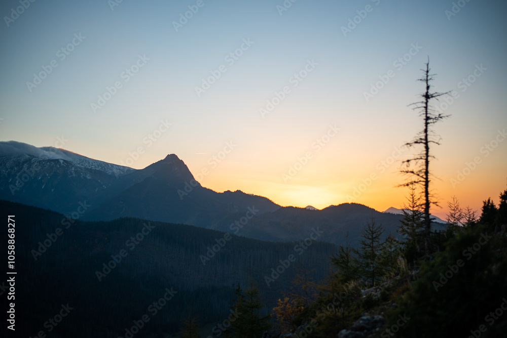 Obraz premium The sunset atop Mount Kopieniec in Zakopane, Poland, casts a warm glow over the Tatra Mountains
