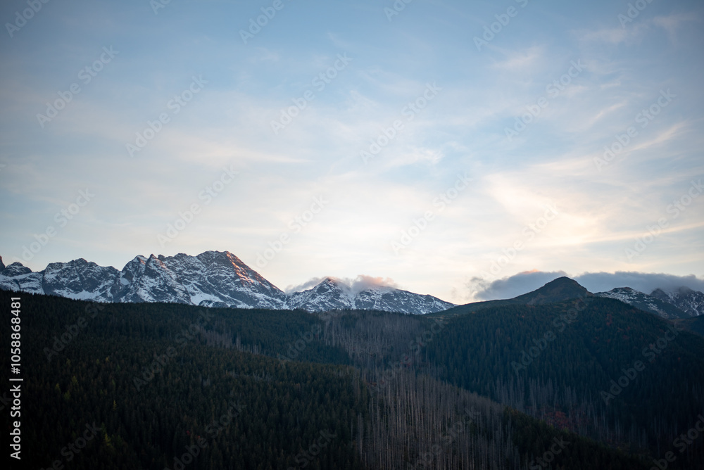 Obraz premium The sunset atop Mount Kopieniec in Zakopane, Poland, casts a warm glow over the Tatra Mountains, creating a stunning landscape 