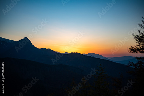 The sunset atop Mount Kopieniec in Zakopane, Poland, casts a warm glow over the Tatra Mountains, creating a stunning landscape