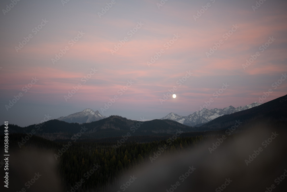Obraz premium The sunset atop Mount Kopieniec in Zakopane, Poland, casts a warm glow over the Tatra Mountains, creating a stunning landscape 
