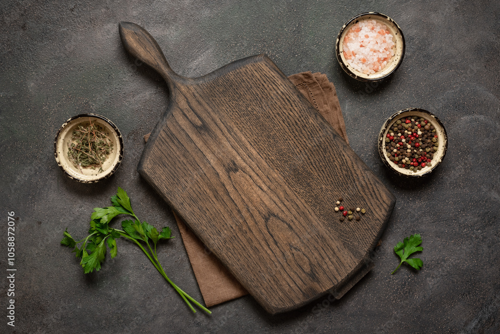 Culinary background with empty wooden cutting board, spices, linen napkin, parsley, dark grunge background. Top view, flat lay, copy space. Culinary background with empty wooden cutting board, spices, linen napkin, parsley, dark grunge background. Top view, flat lay, copy space.