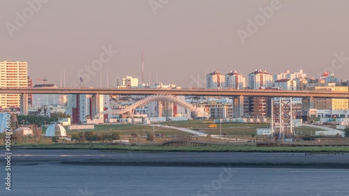 Park Tejo and river timelapse in Lisbon with park of Nations district modern architecture on a background, Portugal. View with Vasco da Gama Bridge from walking route Percurso Ribeirinho de Loures photo