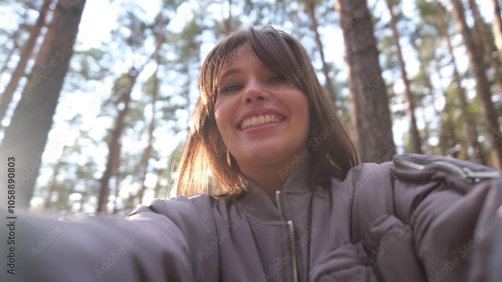 The girl films herself on camera and spins, enjoying her vacation in the forest. Young beautiful woman breathing fresh air at sunset The girl films herself on camera and spins, enjoying her vacation in the forest. Young beautiful woman breathing fresh air at sunset