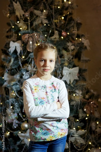 a little girl dressed in a red dress sitting in a room with Christmas decoration