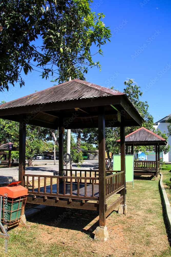 garden view with green grass and gazebo during the day with a blue background garden view with green grass and gazebo during the day with a blue background