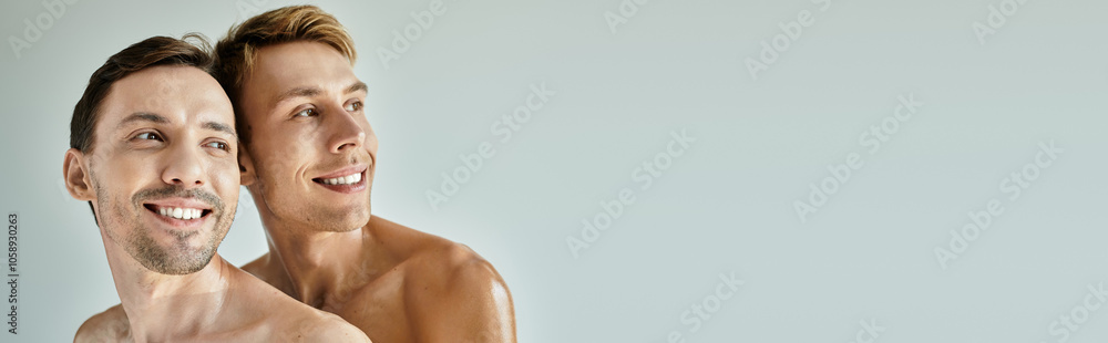 Two young men share a moment of happiness, smiling against a light backdrop. Two young men share a moment of happiness, smiling against a light backdrop.