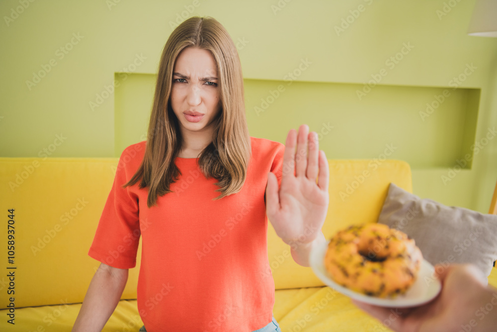 Photo of nice young girl stop gesture avoid donut wear orange clothes enjoy modern bright cozy spring interior flat indoors Photo of nice young girl stop gesture avoid donut wear orange clothes enjoy modern bright cozy spring interior flat indoors