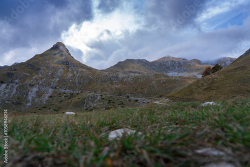 Dark, sinister view of the Durmitor mountains in autumn. The illuminated mountainside, dark clouds add charm. Travel concept. Zabljak, Montenegro photo