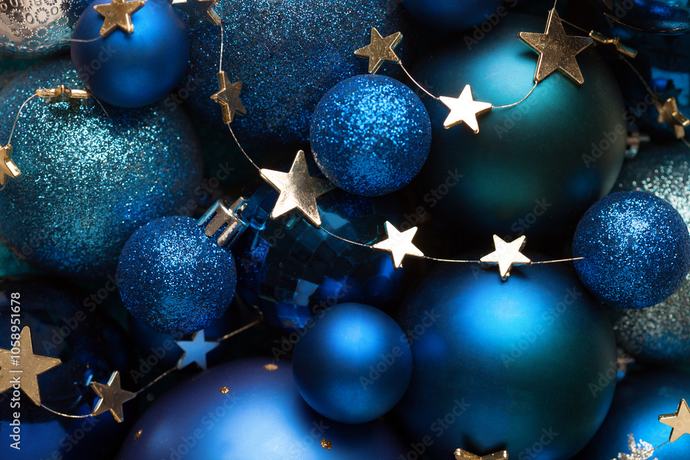 Background with blue Christmas balls and golden stars. Close-up of a pile of blue Christmas balls, different sizes, shades and textures. Flat lay