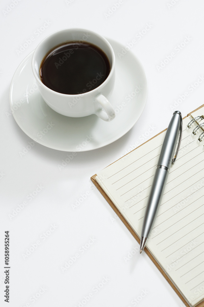 Coffee and a blank notepad with a pen