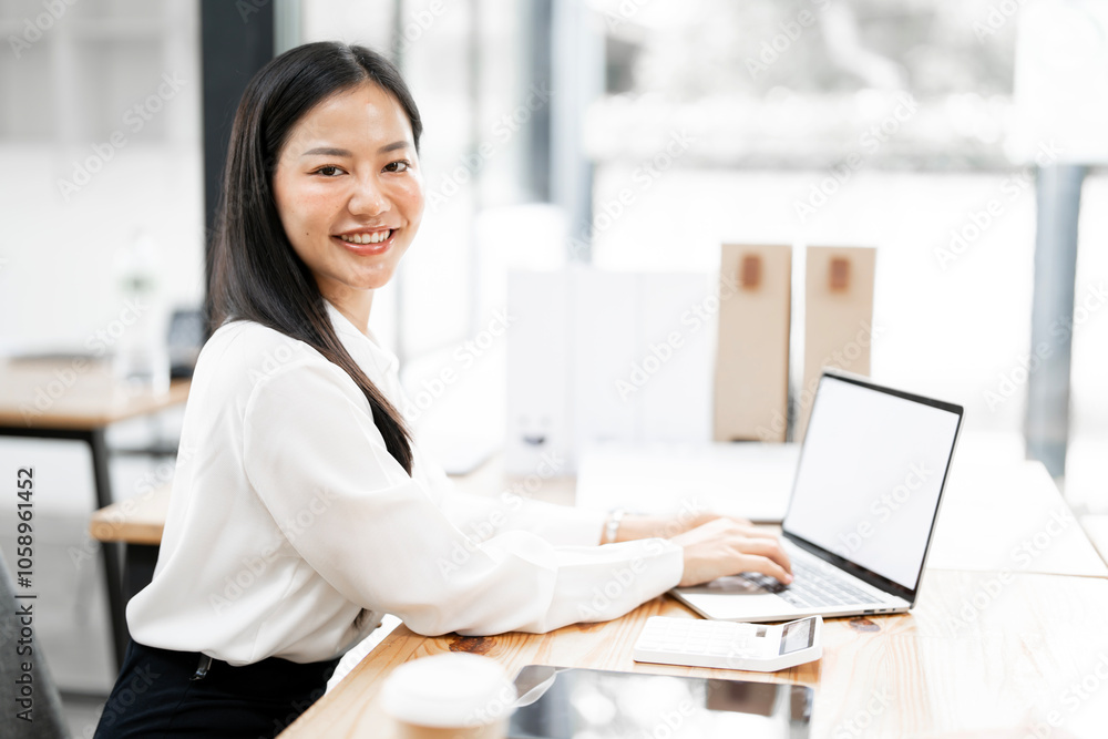 Young attractive businesswoman working on her project with laptop computer in modern office room.