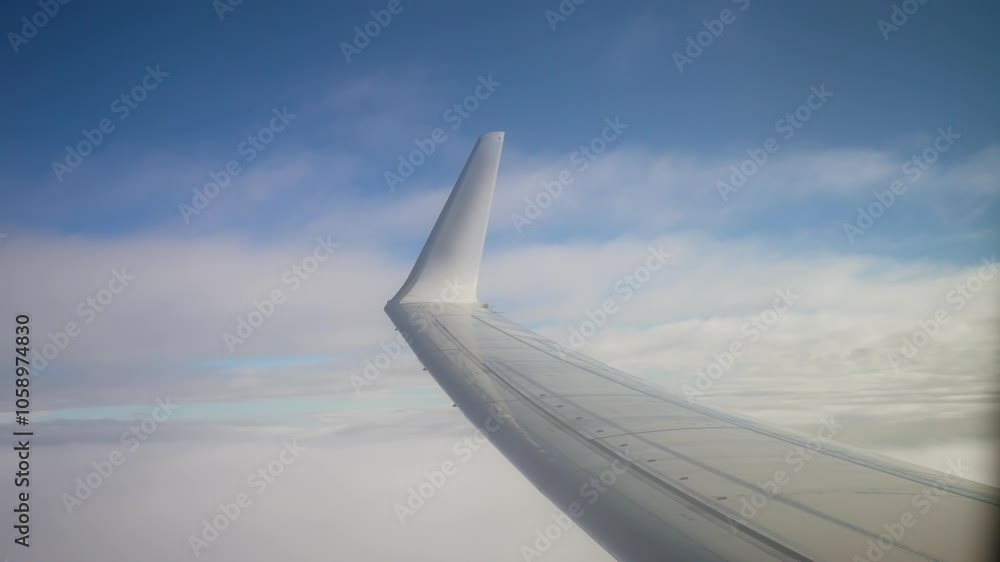 View From Airplane Wing Soaring Above Clouds on Clear Day, Showcasing Blue Skies and Ethereal Cloud Formations. Vacation and world air travel concept View From Airplane Wing Soaring Above Clouds on Clear Day, Showcasing Blue Skies and Ethereal Cloud Formations. Vacation and world air travel concept