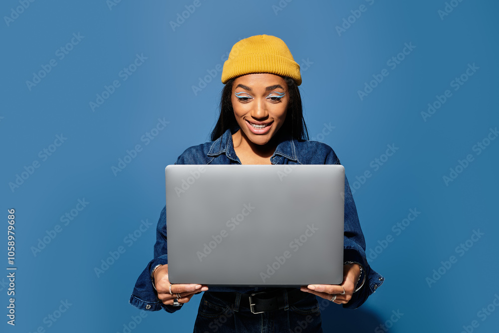 A young woman in a stylish outfit smiles at her laptop in a cheerful setting. A young woman in a stylish outfit smiles at her laptop in a cheerful setting.