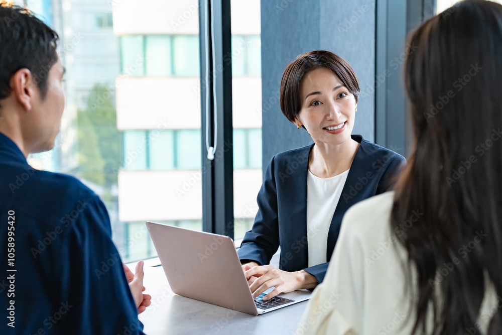 説明をするスーツを着た女性と話を聞くカップル 説明をするスーツを着た女性と話を聞くカップル