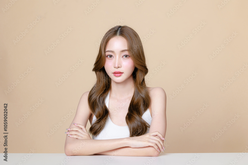 Young Asian beauty woman curly long hair with korean makeup style touch her face and perfect skin on isolated beige background. Facial treatment, Cosmetology, plastic surgery. Young Asian beauty woman curly long hair with korean makeup style touch her face and perfect skin on isolated beige background. Facial treatment, Cosmetology, plastic surgery.