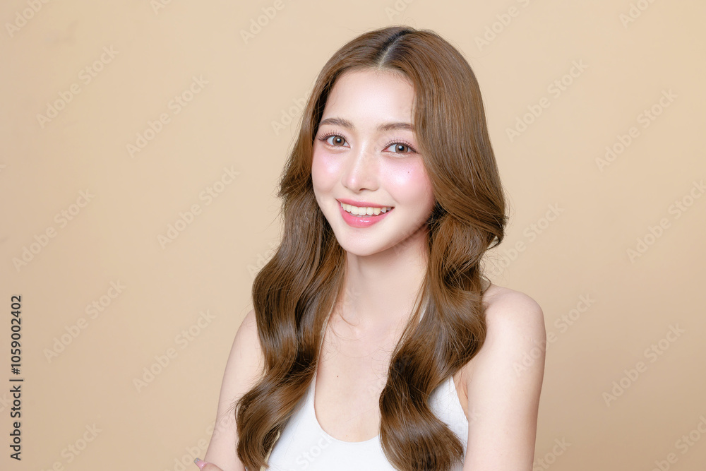 Fototapeta premium Young Asian beauty woman curly long hair with korean makeup style touch her face and perfect skin on isolated beige background. Facial treatment, Cosmetology, plastic surgery.