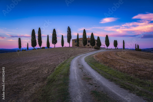 Ein Haus mit Zypressen im Val d'Orcia der Toskana bei Sonnenuntergang, Italien photo