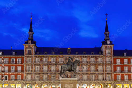 Obraz na płótnie Illuminated at twilight, Madrid's historic Plaza Mayor showcases intricate architecture and the bronze statue of King Philip III, a captivating symbol of Spain's cultural heritage. w salonie