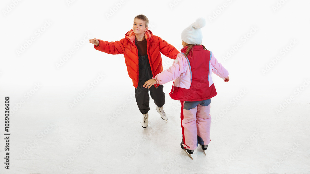 Obraz premium Happy children, boy and girl, brother and sister in bright warm, winter clothes enjoying time on ice rink, having fun during skating. Concept of winter, vacation, holiday, leisure activity