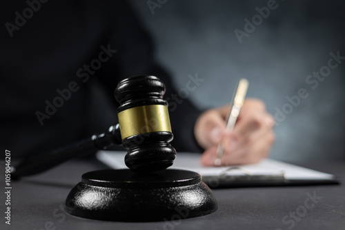 Judge's gavel and papers against judge background photo