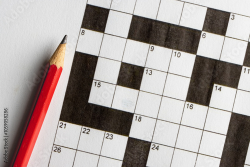 Empty, unfinished crossword puzzle, black and white crossword puzzle with a red pencil. On black background. 