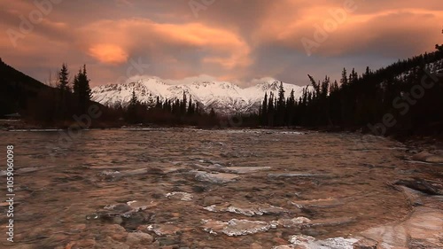 Sunset clouds over the Grey Mountain ridge and Wheaton River. Snow has covered the mountains as winter is gradual blanketing the Yukon; Yukon, Canada