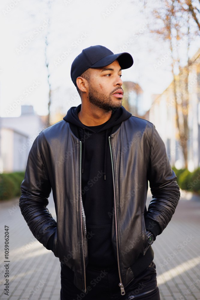 African american man in stylish dark outfit walking on urban street in autumn African american man in stylish dark outfit walking on urban street in autumn