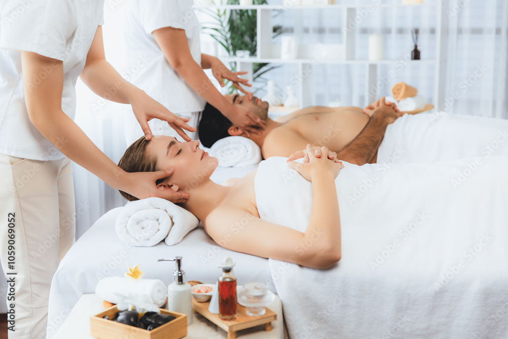 Naklejka premium Caucasian couple enjoying relaxing anti-stress head massage and pampering facial beauty skin recreation leisure in dayspa modern light ambient at luxury resort or hotel spa salon. Quiescent