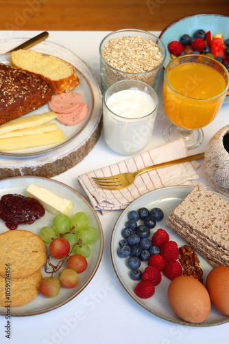 Assortment of various breakfast foods and drinks on the white table. Selective focus.