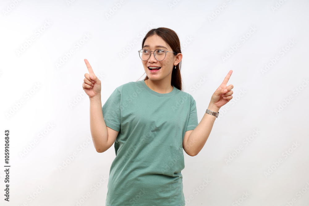 Amused young asian woman introduce new product sharing promo with you, raise hands pointing fingers up smiling broadly, look excited and upbeat, enthusiastic advertising, stand white background Amused young asian woman introduce new product sharing promo with you, raise hands pointing fingers up smiling broadly, look excited and upbeat, enthusiastic advertising, stand white background