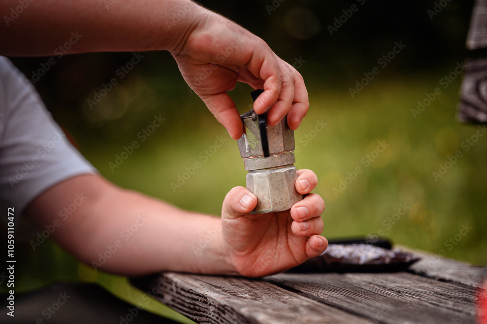 Fototapeta premium Hands Preparing Moka Pot for Coffee Outdoors