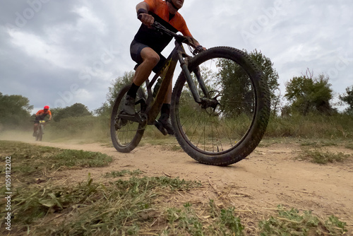 athlete riding mountain bike on dusty trail in cross country race