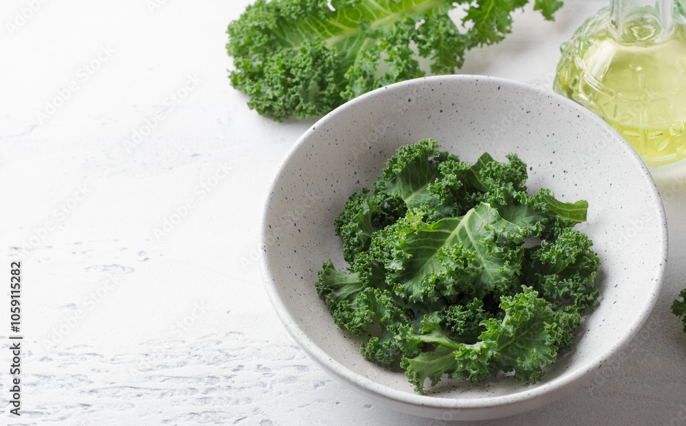 Chopped fresh curly kale leaves in a ceramic bowl on a light gray background, copy space. Healthy detox food Chopped fresh curly kale leaves in a ceramic bowl on a light gray background, copy space. Healthy detox food