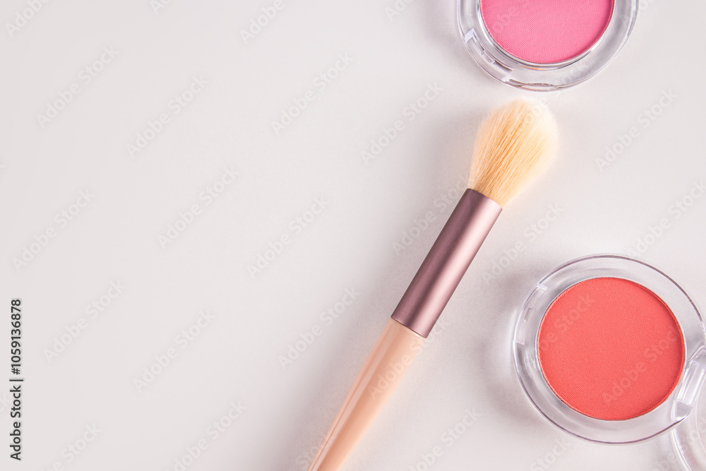 Two round packs of pink and peach blush on a white background with a beautiful makeup brush. top view. A copy of the space. The concept of beauty. Two round packs of pink and peach blush on a white background with a beautiful makeup brush. top view. A copy of the space. The concept of beauty.