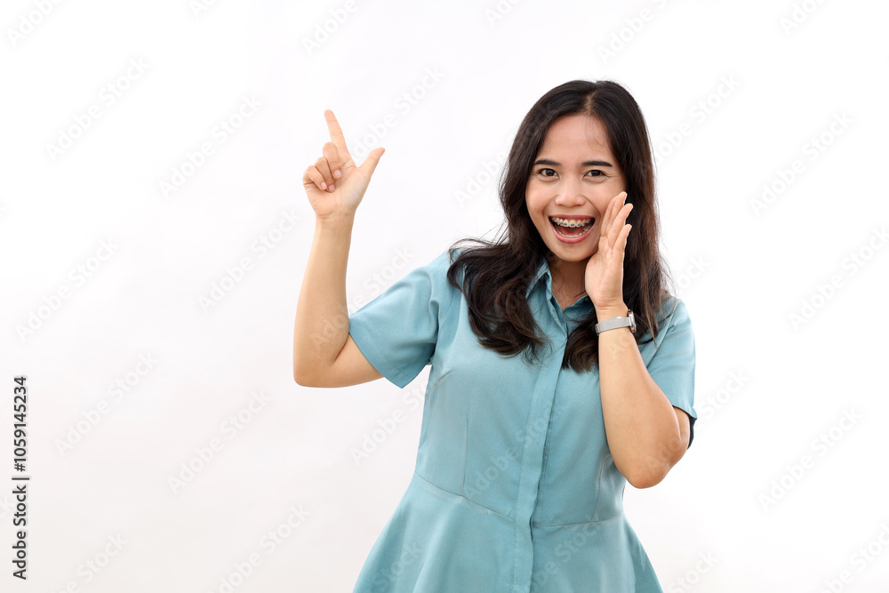 Excited young woman, expresses positive emotions indicates away on blank copy space shows something pleasant, isolated white background Excited young woman, expresses positive emotions indicates away on blank copy space shows something pleasant, isolated white background