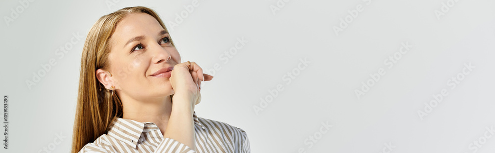 A woman with long hair reflects thoughtfully while dressed in a chic striped top A woman with long hair reflects thoughtfully while dressed in a chic striped top