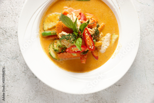 Vegetable red curry in a bowl topped with basil and chili photo