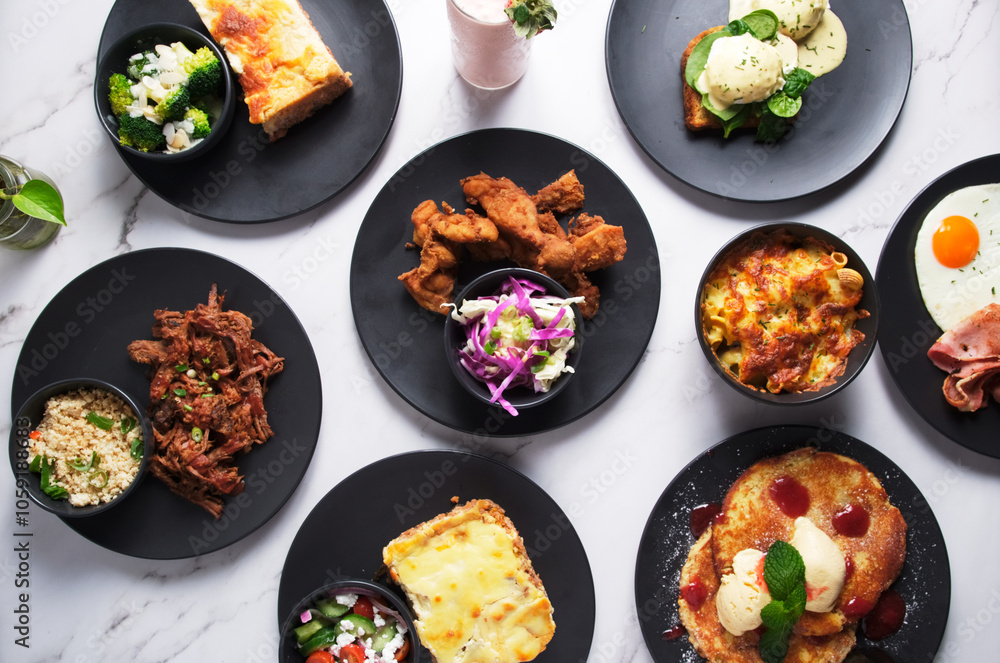 a variety of dishes served on black plates and arranged on a white surface a variety of dishes served on black plates and arranged on a white surface